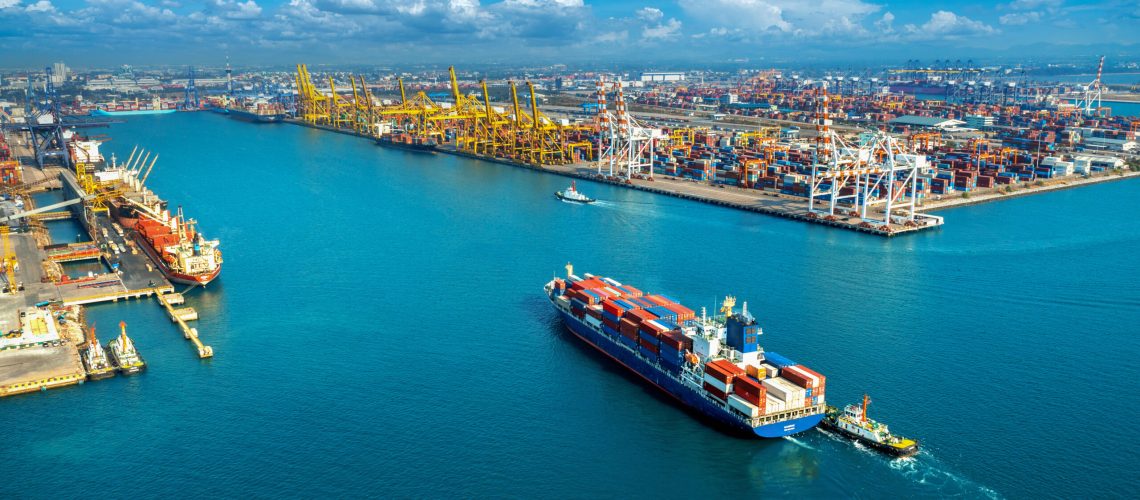 Aerial view of cargo ship and cargo container in harbor.